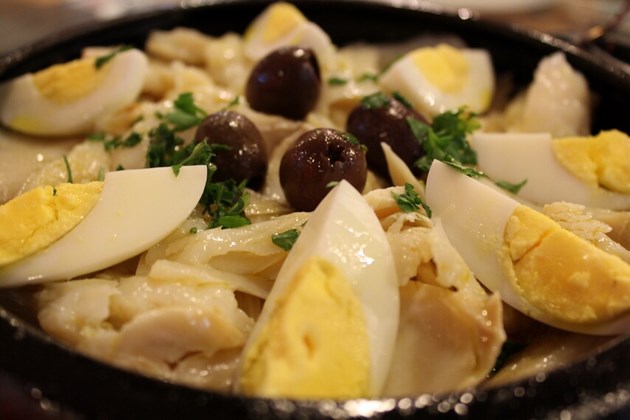 Bacalhau da vovó Mazzarello - Lascas de bacalhau cozidas ao azeite, batatas, pimentão, cebola, ovos e azeitonas.