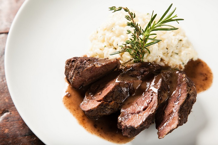 Bochechas de vitela assadas com risotto de ervas aromáticas. Foto: Rodrigo Castro