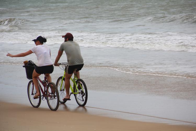 Na maré baixa, no fim da manhã, é a hora do passeio de bicicleta, com pedaladas na areia. Foto: Eduardo Madeira